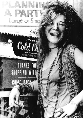 Black and white photo of a Janis Joplin with long hair and glasses, holding a product, with advertisements in the background.